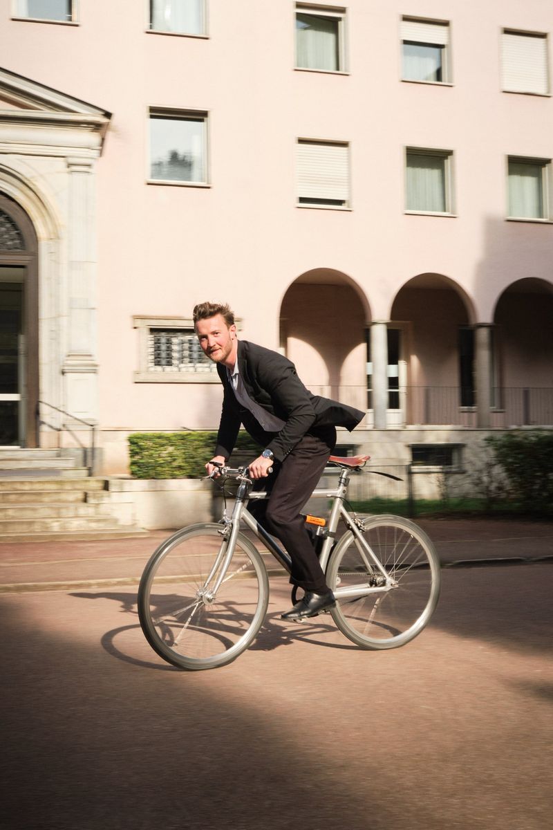 Robin, formateur Revit, à vélo devant une façade rose